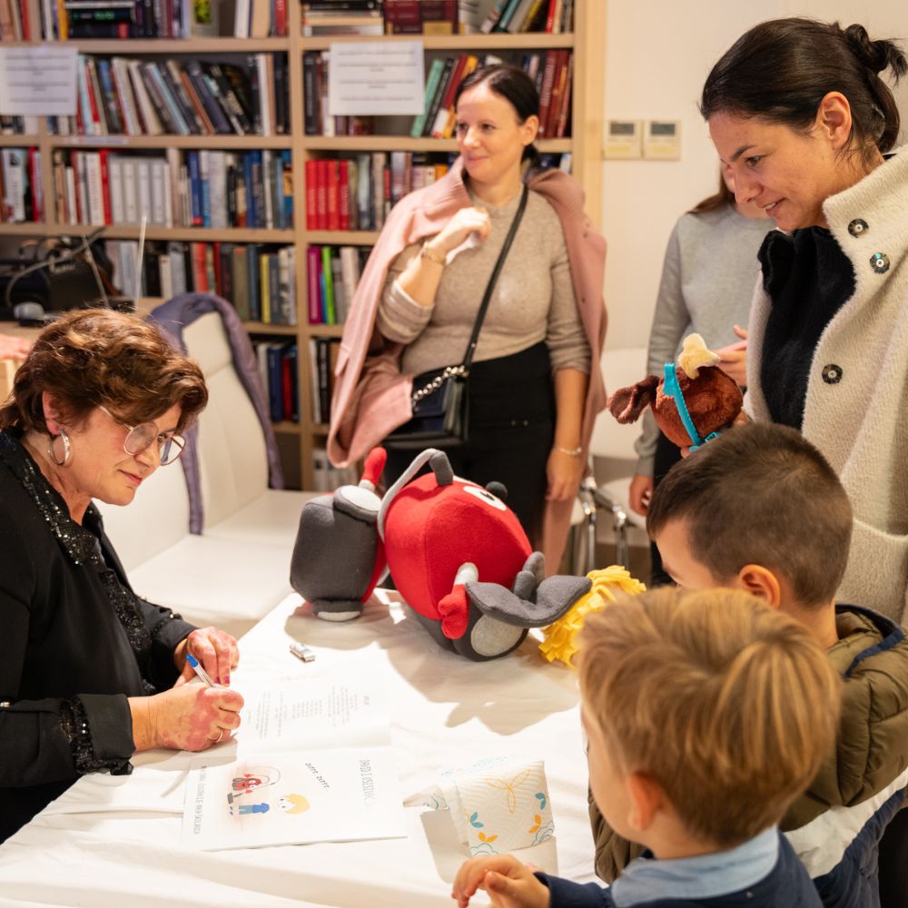 Promocija slikovnice David i usisivač Šaša - Djeca i odrasli okupljeni na promociji slikovnice u Gradskoj knjižnici Novalja, uživajući u druženju i čaroliji priče autorice Maje Cimbal.