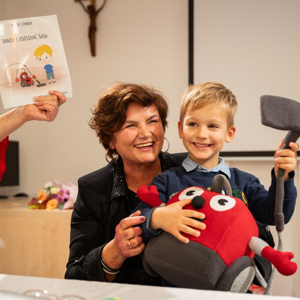 Promocija slikovnice David i usisivač Šaša - Djeca i odrasli okupljeni na promociji slikovnice u Gradskoj knjižnici Novalja, uživajući u druženju i čaroliji priče autorice Maje Cimbal.