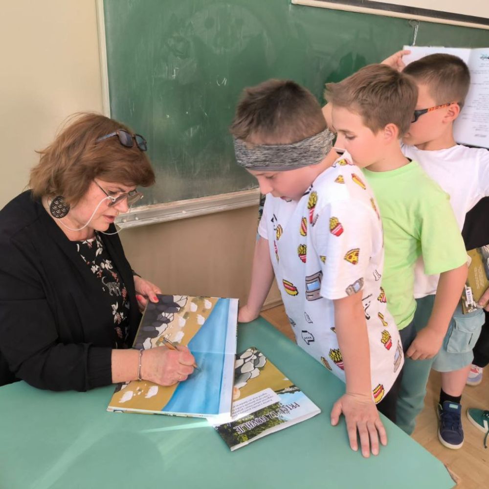 Radionica s učenicima OŠ A. G. Matoša u Novalji: Maja Cimbal čita „Priče iz Novalje – David otkriva legendu o Caskoj“ i razgovara s djecom.