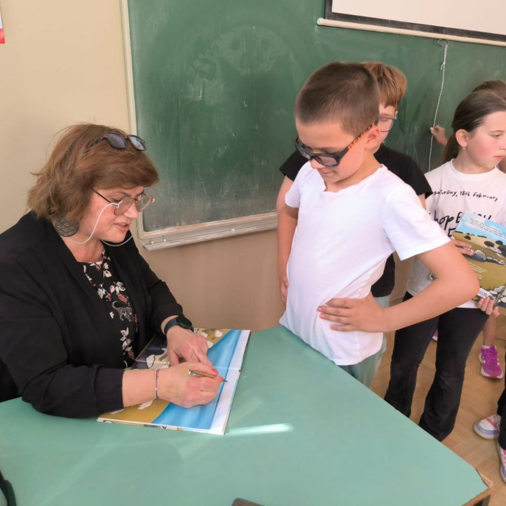 Radionica s učenicima OŠ A. G. Matoša u Novalji: Maja Cimbal čita „Priče iz Novalje – David otkriva legendu o Caskoj“ i razgovara s djecom.