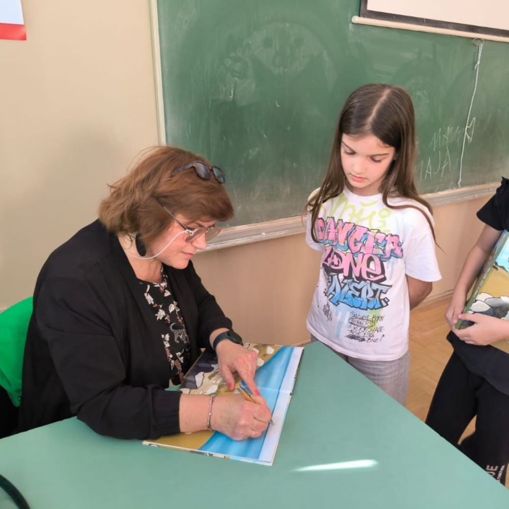Radionica s učenicima OŠ A. G. Matoša u Novalji: Maja Cimbal čita „Priče iz Novalje – David otkriva legendu o Caskoj“ i razgovara s djecom.